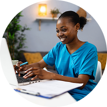 Healthcare provider smiling and typing on a laptop